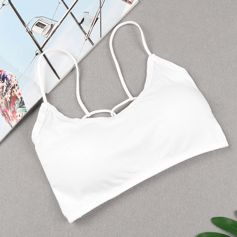 Stylish white wireless women's sports bra with open back, ideal for yoga, made of breathable modal, shown on a gray background.